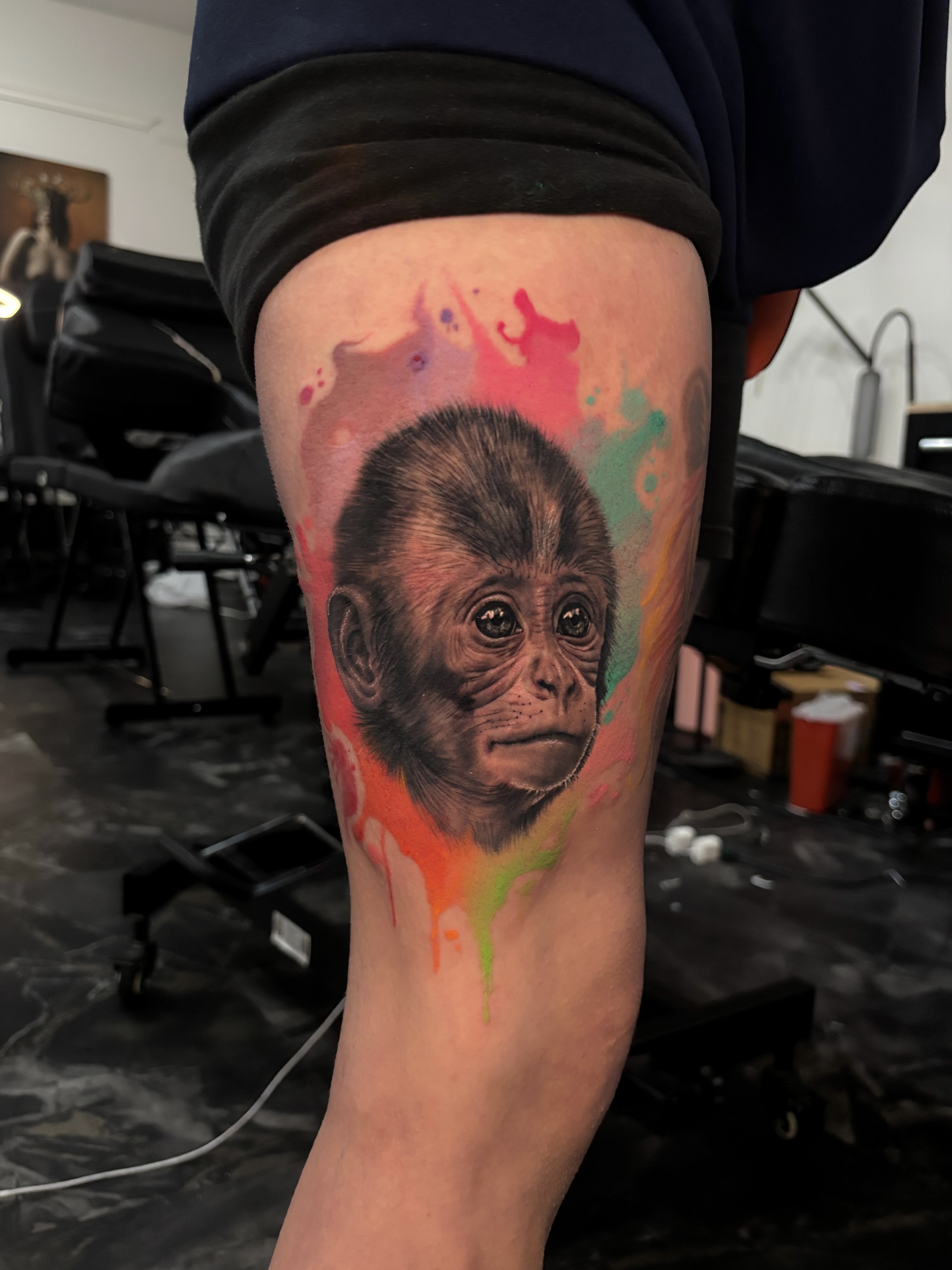 Colorful monkey portrait with watercolor splashes tattoo